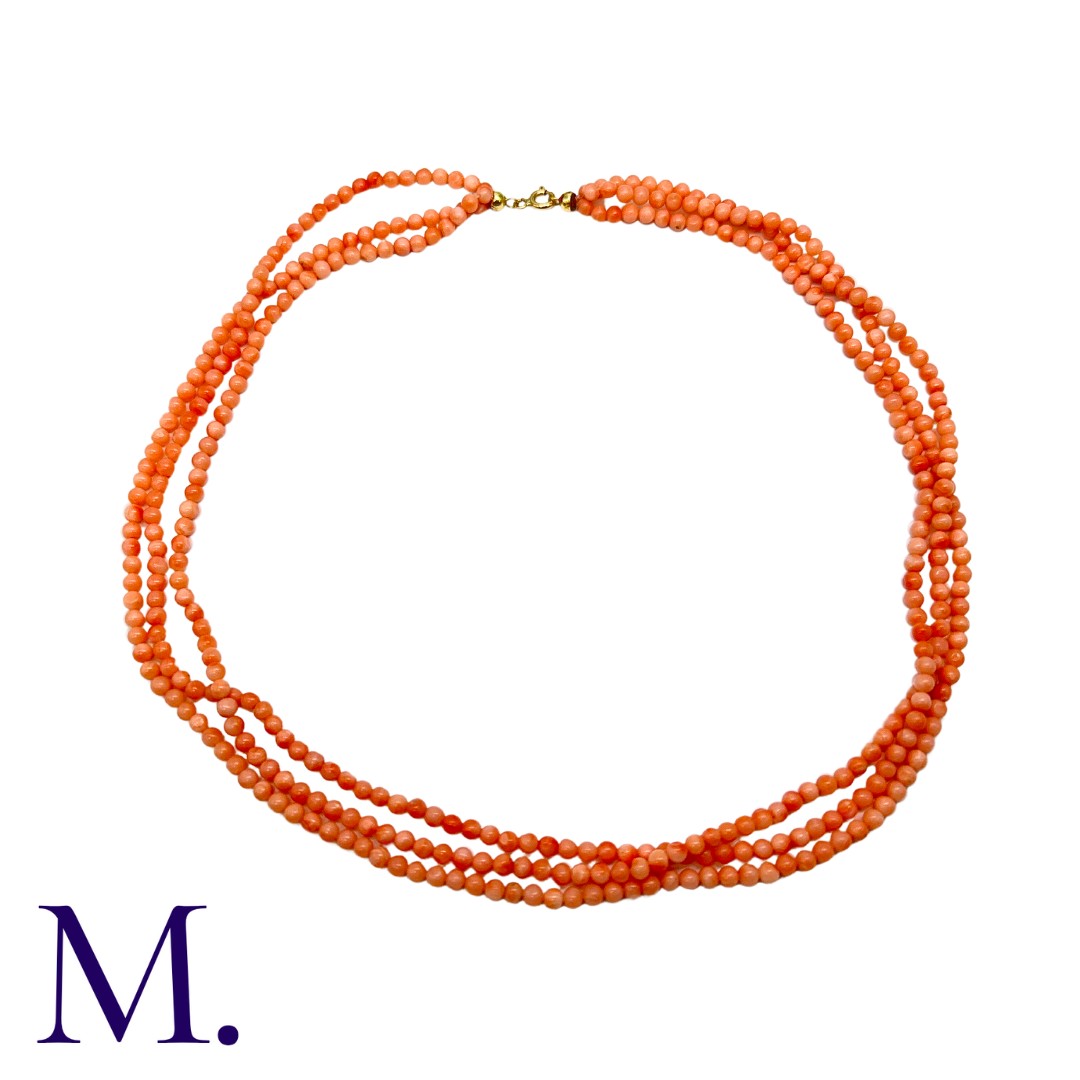 An Angel Skin Coral Necklace in three strands, with 18K clasp. Clasp marked '750'. Size: 55cm