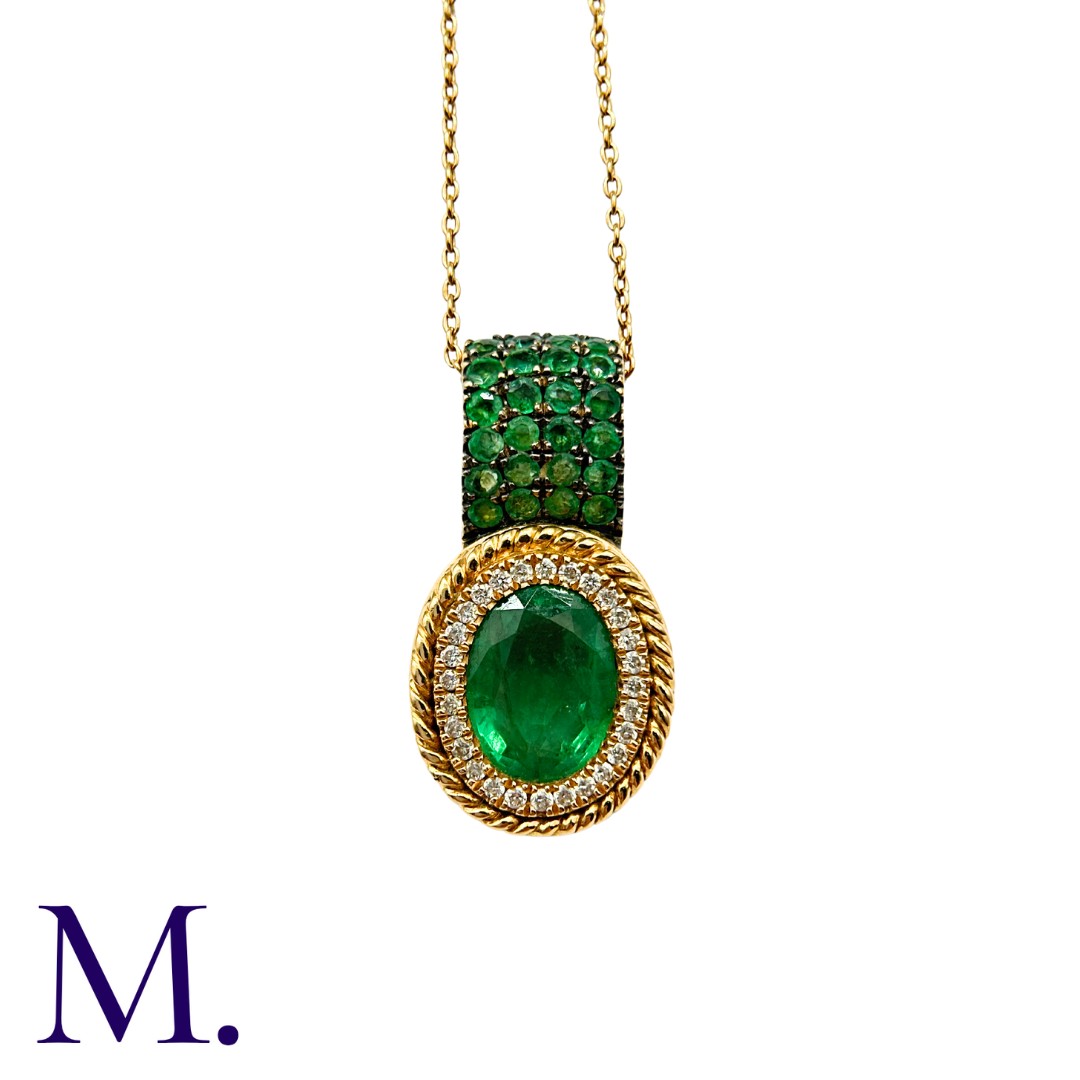 An Emerald & Diamond Pendant with Chain in 18K yellow gold, set with an oval cut emerald (