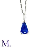 A Sapphire and Diamond Pendant with Chain in 18K white gold, set with a tapered faceted sapphire (