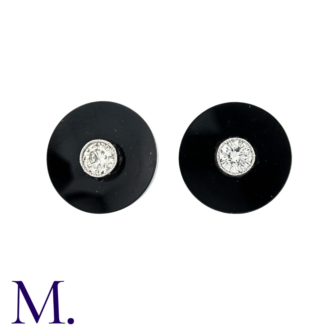 A Pair Of Onyx And Diamond Stud Earrings in platinum, the concaved onyx discs each set centrally
