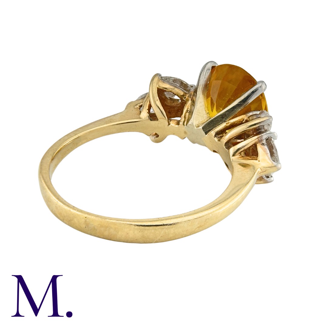 A Sapphire and Diamond Ring in 14K yellow gold, set with an oval cut yellow-orange sapphire of - Image 3 of 3