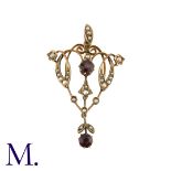 A Garnet And Pearl Pendant in 9k yellow gold, the open work foliate and scrolling form set with a