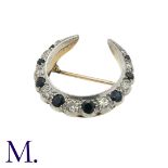 A Sapphire and Diamond Crescent Brooch in yellow gold and silver, of crescent moon design set with