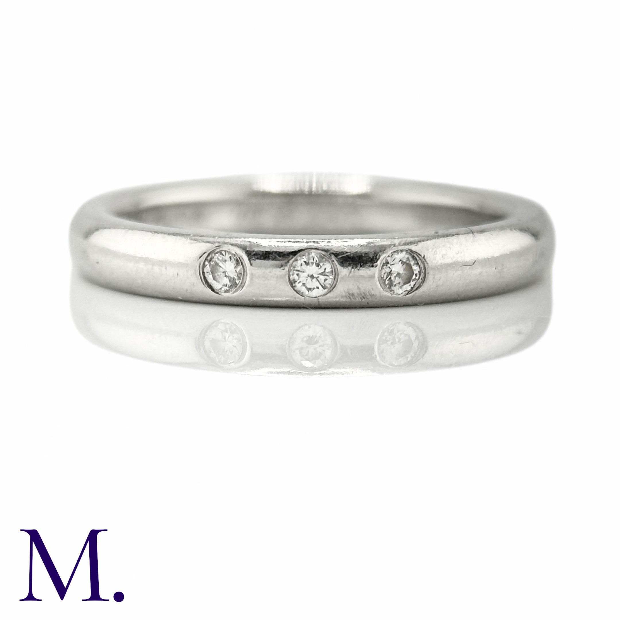 TIFFANY & CO. A Diamond Accent Ring in platinum, set with three round cut diamonds weighing