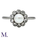 A Pearl And Diamond Cluster Ring in 18k white gold and platinum, set with a principal pearl of
