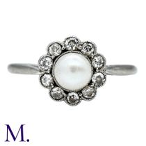 A Pearl And Diamond Cluster Ring in 18k white gold and platinum, set with a principal pearl of