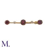 A Garnet and Diamond Bar Brooch in yellow gold, set with three bright red garnets with two smaller