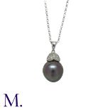 A Black Pearl and Diamond Pendant and Chain in 18K white gold, set with an oval black pearl with