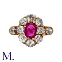 A Ruby & Diamond Cluster Ring in rose gold, set with a principal oval cut ruby of approximately 0.