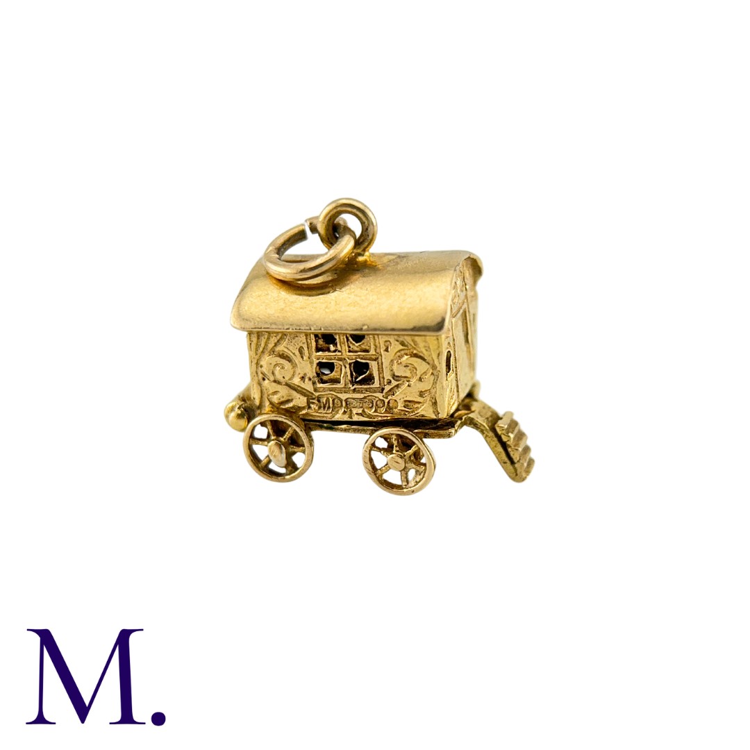 A Group of Gold Charms including a wagon, a camel, a handbag, a water carrier, a boot and a cross.