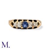 A Sapphire And Diamond Ring in 15k yellow gold, set centrally with a round cut blue sapphire,