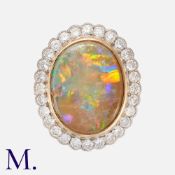 An Opal And Diamond Cluster Ring in 18k gold and platinum, comprising a principal rub-over set