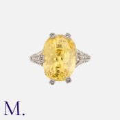 A Yellow Sapphire And Diamond Ring in platinum, set with a principal yellow sapphire of