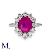 A Pink Sapphire & Diamond Cluster Ring in 18K white gold ring, with a natural oval cut pink sapphire
