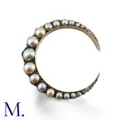 A Pearl And Diamond Crescent Brooch in yellow gold and silver, designed as a crescent moon set