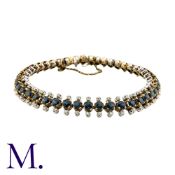 A Sapphire And Diamond Bracelet in 14k yellow and white gold, set with a central row of round cut