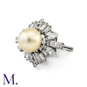 A Pearl And Diamond Cluster Ring in 18k white gold, set centrally with a pearl of 9.5mm within a
