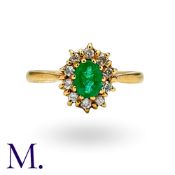 An Emerald & Diamond Cluster Ring in 18K yellow gold, set with oval-cut emerald to the centre with