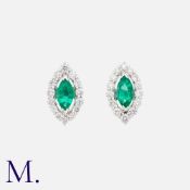 A Pair Of Emerald And Diamond Earrings in 18k white gold, each comprising a marquise cut emerald