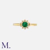 An Emerald and Diamond Ring in 18ct yellow gold, set with a round cut emerald to the centre with ten