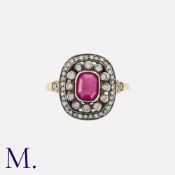 A Ruby and Diamond Cluster Ring in 18k yellow gold and silver, comprising a stepped cut ruby