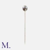 TIFFANY & CO. A Natural Black Pearl Stick Pin in 18k white gold, the terminal set with a button