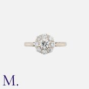 A Diamond Cluster Ring in 18k white gold, comprising a central round cut diamond within a border