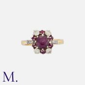 A Ruby and Diamond Cluster Ring in 18K yellow and white gold, set with a ruby to the centre weighing