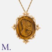 A Tigers Eye Cameo Pendant Necklace in 9k yellow gold, the pendant set with a carved tigers eye