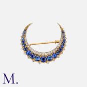 An Antique Sapphire and Diamond Crescent Brooch in 18K yellow and white gold, set with 21 cushion