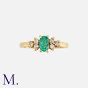 An Emerald & Diamond Ring in 18K yellow gold with an oval cut emerald to the centre with three round