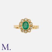 An Emerald & Diamond Cluster Ring in 18K yellow gold, set with oval-cut emerald to the centre with
