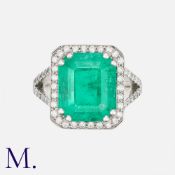 A Colombian Emerald & Diamond Ring in platinum, set with a stepped octagonal cut emerald weighing