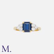 A Sapphire And Diamond Ring in 18k yellow gold, the central step cut sapphire of approximately 1.