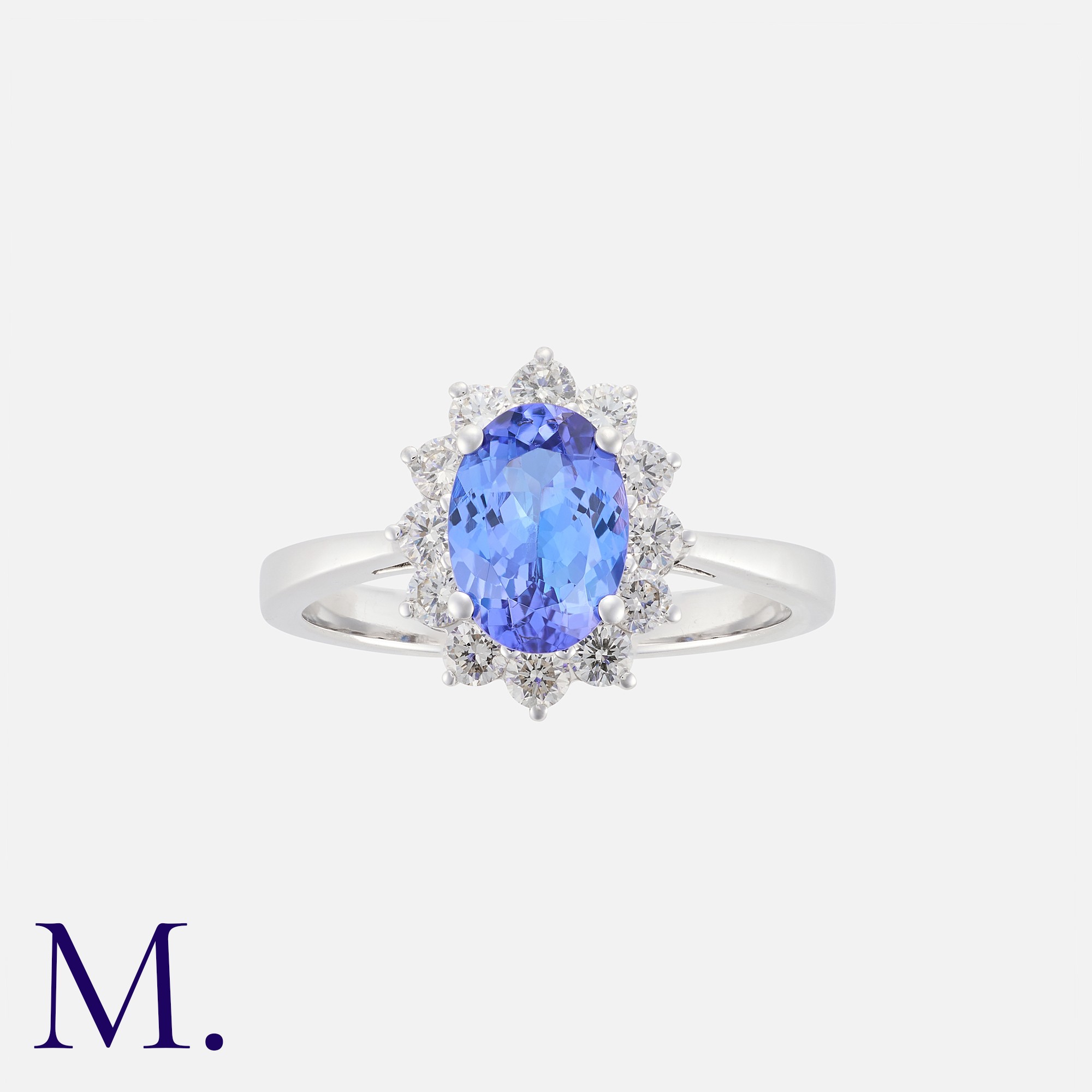 A Tanzanite And Diamond Cluster Ring in 18k white gold, set centrally with an oval cut tanzanite