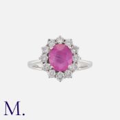 A Pink Sapphire & Diamond Cluster Ring in 18K white gold ring, with a natural oval cut pink sapphire