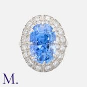 An Impressive Ceylon Sapphire & Diamond Cluster Ring in 18K white gold, set with a large oval-cut