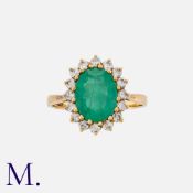 An Emerald & Diamond Cluster Ring in 18K yellow gold, with an oval-cut emerald to the centre with 16