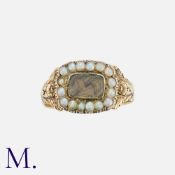 A Georgian Mourning Ring in yellow gold, with locket to the front and pearls in surround.