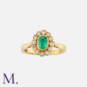 An Emerald and Diamond Ring in 18K yellow gold, set with an oval cut emerald, with twelve round