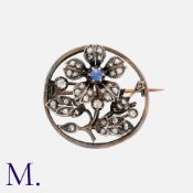 A Sapphire and Diamond Flower Brooch in 18k yellow gold and silver, the floral form set with a round