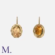 A Pair Of Gemset Earrings in yellow gold and silver, each comprising an oval shaped yellow gemstone,