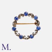 An Edwardian Sapphire and Diamond Brooch in silver and gold with seven old cut sapphires and