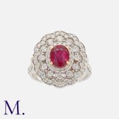 A Ruby and Diamond Cluster Ring in 18K white gold, set to the centre with an oval cut ruby