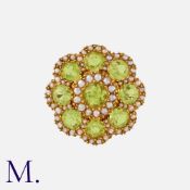A Peridot And Pearl Brooch in yellow gold, of floral form, comprising a cluster of round cut peridot
