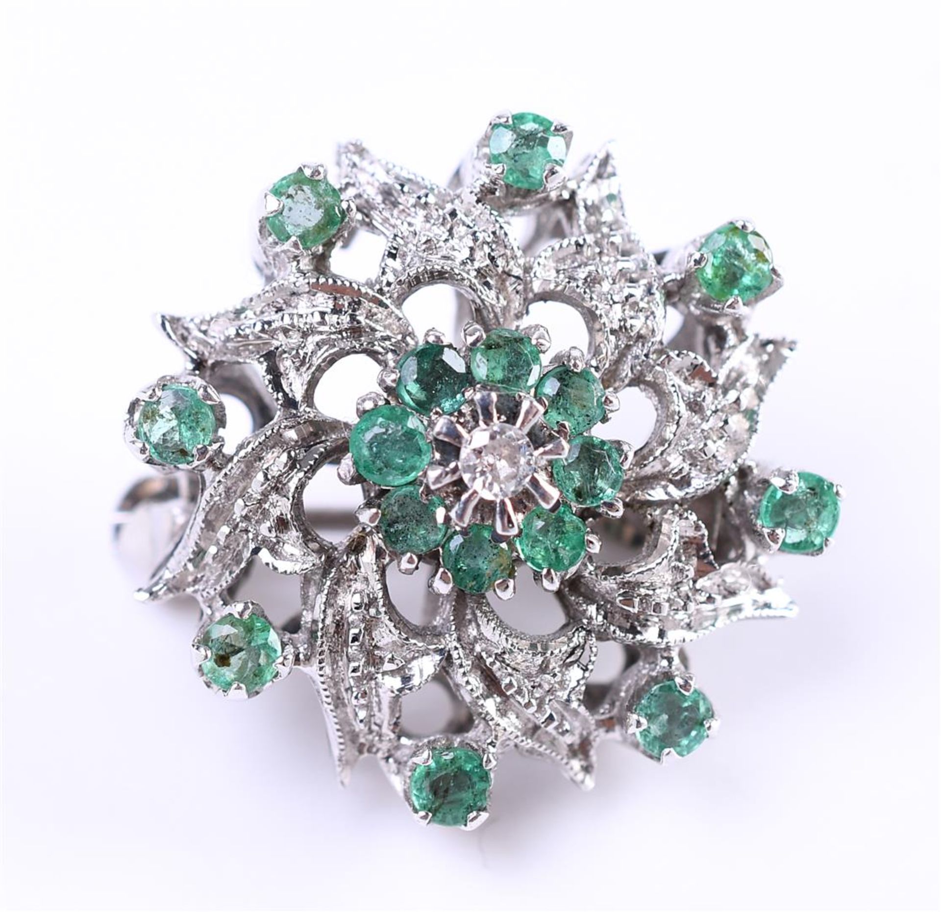 18 carat white gold cluster brooch, set with approximately 16 brilliant cut emeralds