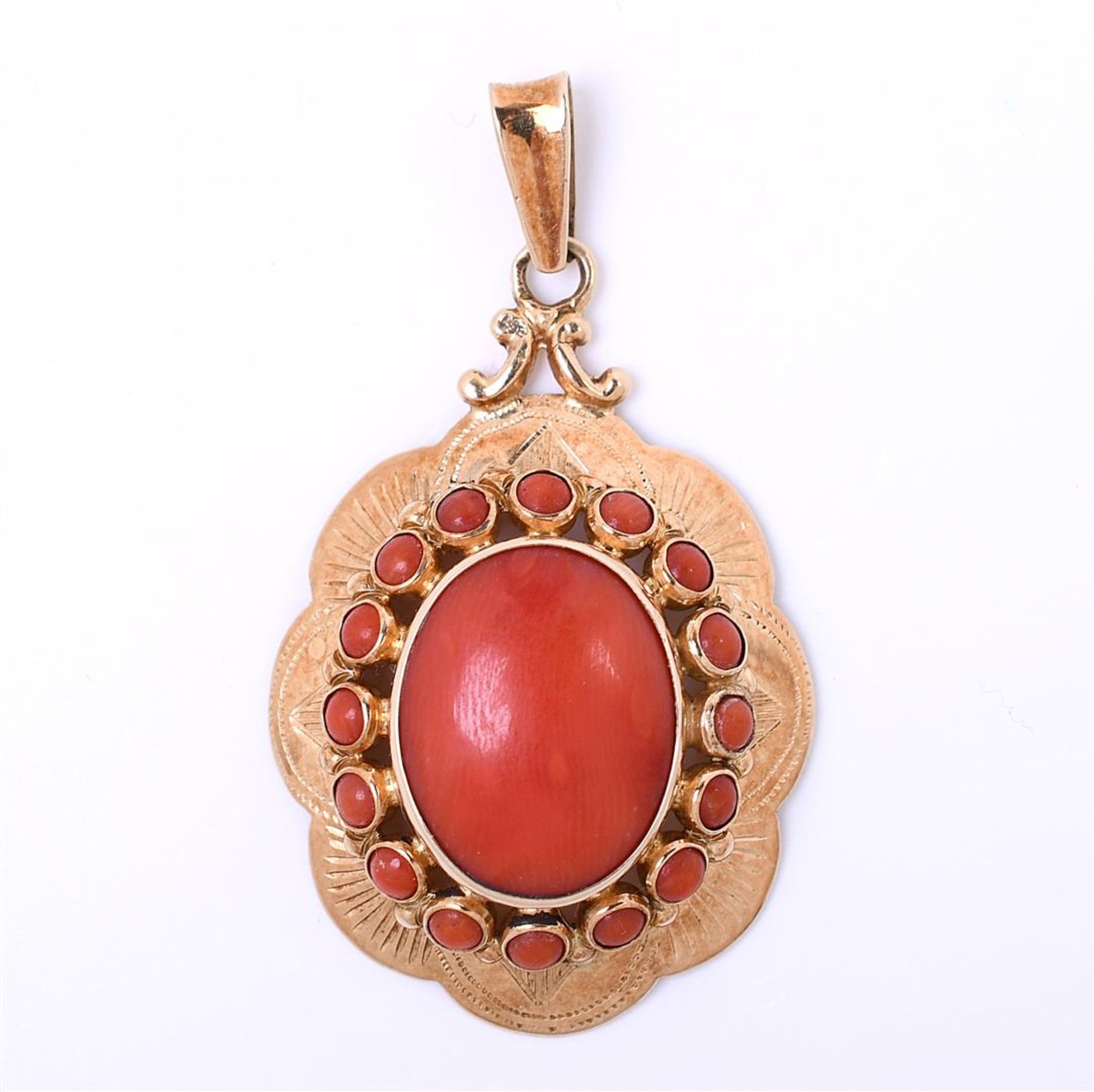 9 carat yellow gold ladies pendant, set in the center with a cabuchon cut red coral
