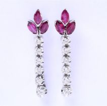 14 carat white gold earrings, each set with 3 oval cut rubies of approximately 3 mm