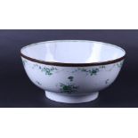 A large porcelain Chine de Commande bowl with a green decoration of flowers, copper ring on rim. Chi
