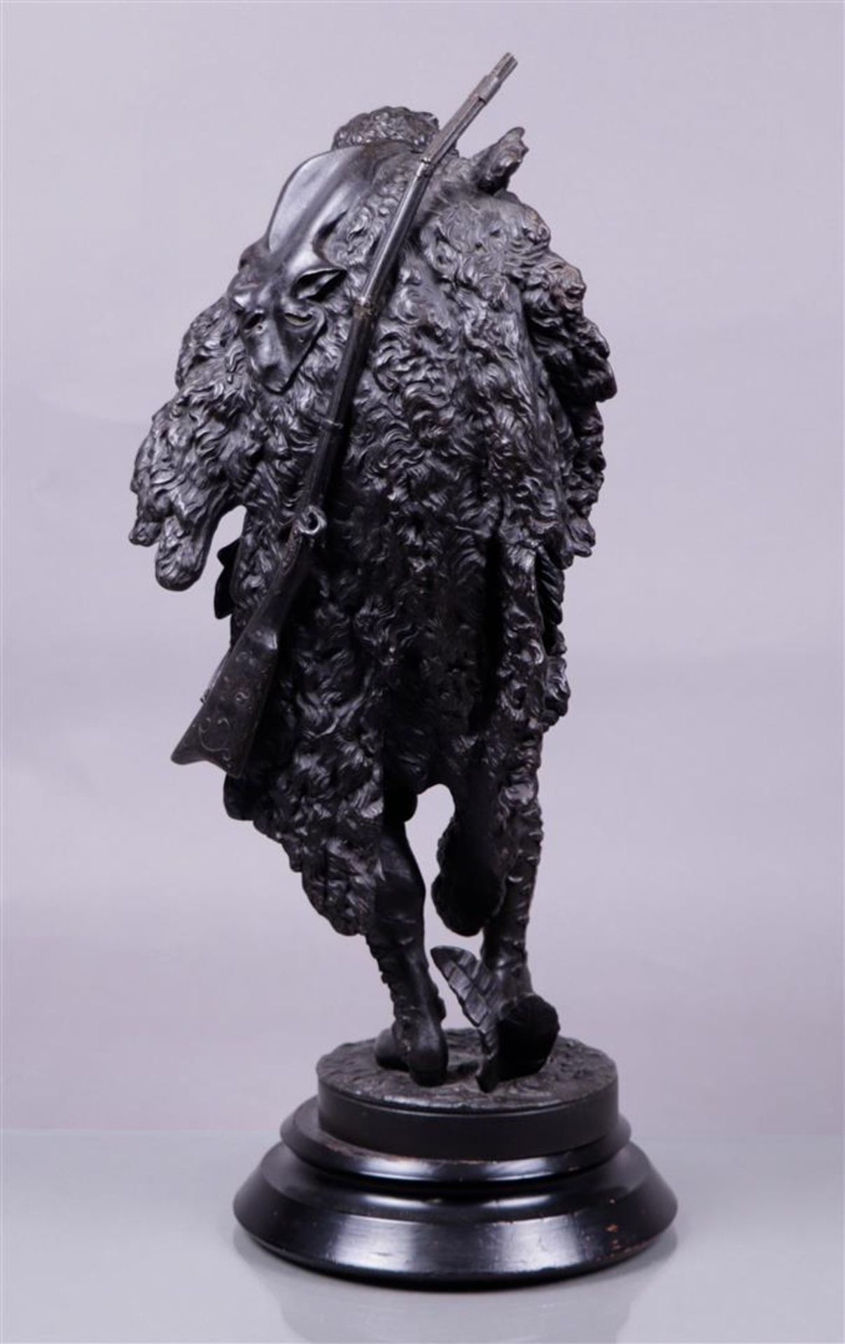 A dark patinated metal statue on a wooden base of a hunter storing a bird in a hunting bag. 19th cen - Bild 2 aus 2